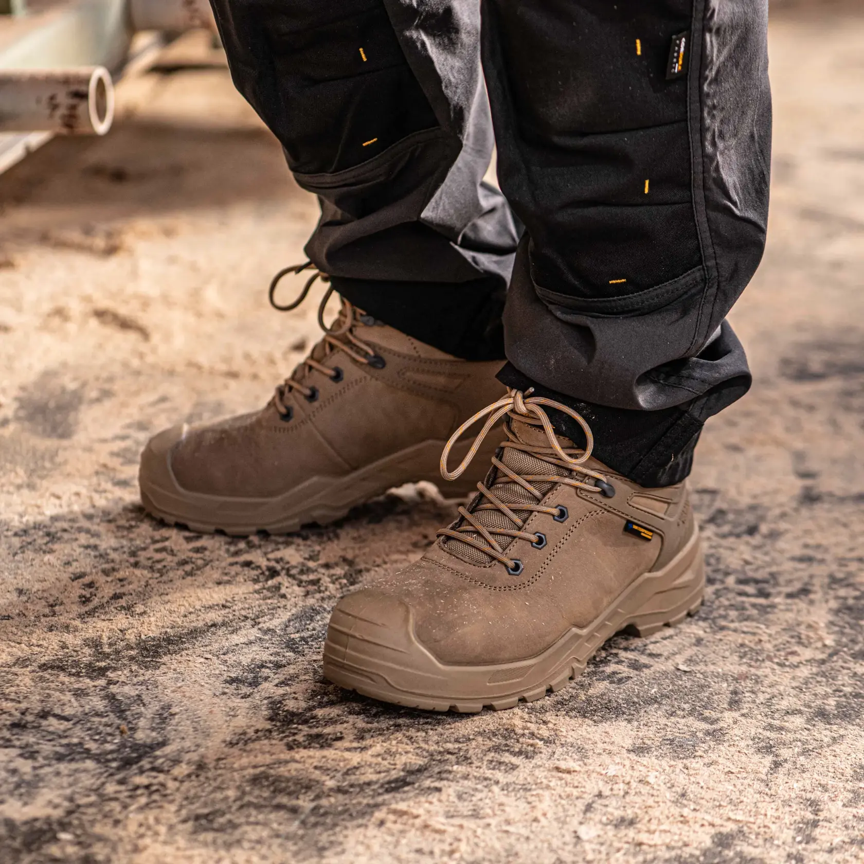 Front view facing left of the DEWALT Hayes men’s safety boot in stone on model on location