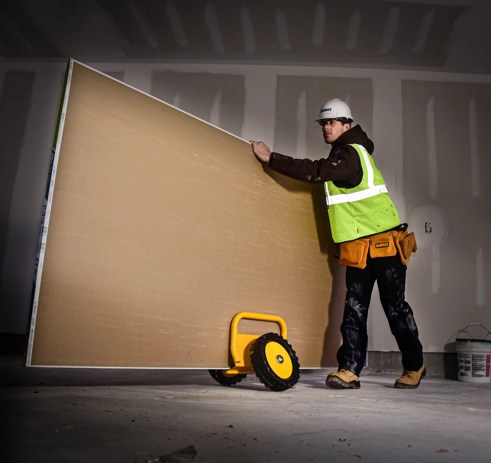 Door and Panel Dolly X L being used to carry a board by a worker.