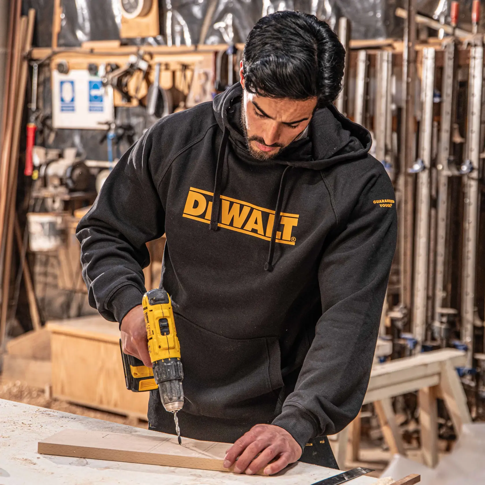 Front view of the DEWALT Rexburg men’s hoodie in black on model on location