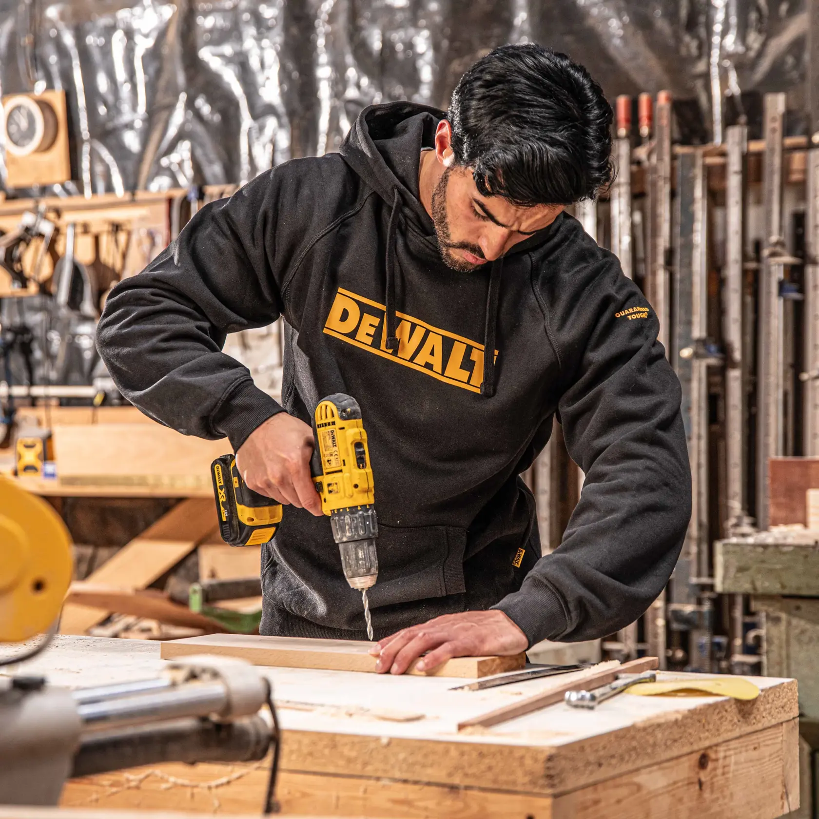 Front view of the DEWALT Rexburg men’s hoodie in black on model on location